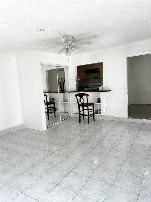 1020 E Rowland Ave, West Covina, CA 91790 - living room with ceiling fan, a textured ceiling, and tile patterned floors