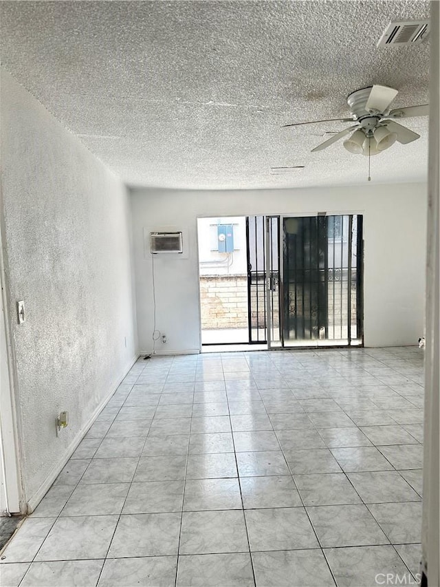 1020 E Rowland Ave, West Covina, CA 91790 - empty room featuring a textured ceiling, a wall unit AC, a textured wall, ceiling fan, and tile patterned flooring