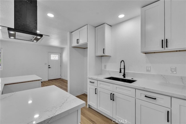 26339 First St, Loma Linda, CA 92318 - kitchen featuring a sink, ventilation hood, white cabinetry, light wood-style floors, and light stone counters