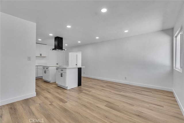 26339 First St, Loma Linda, CA 92318 - kitchen featuring range hood, a kitchen island, light countertops, white cabinets, and baseboards