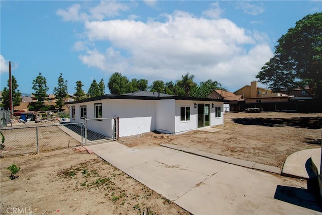 ranch-style home with fence, a gate, and stucco siding