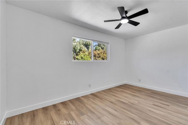 empty room with light wood-style flooring, baseboards, and a ceiling fan