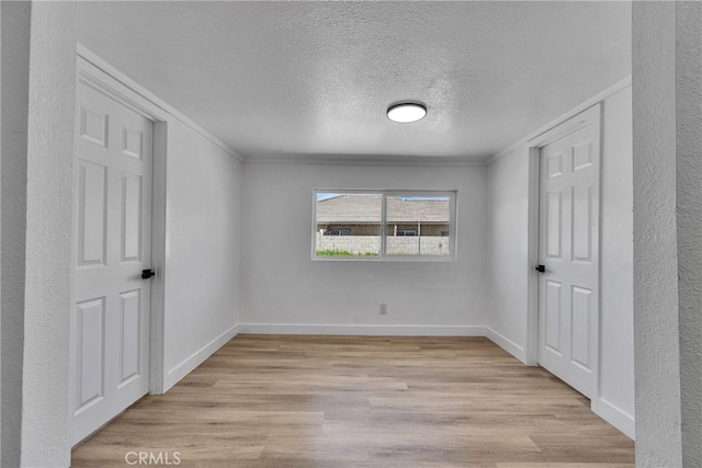26339 First St, Loma Linda, CA 92318 - unfurnished bedroom featuring crown molding, light wood-style flooring, a textured ceiling, and baseboards