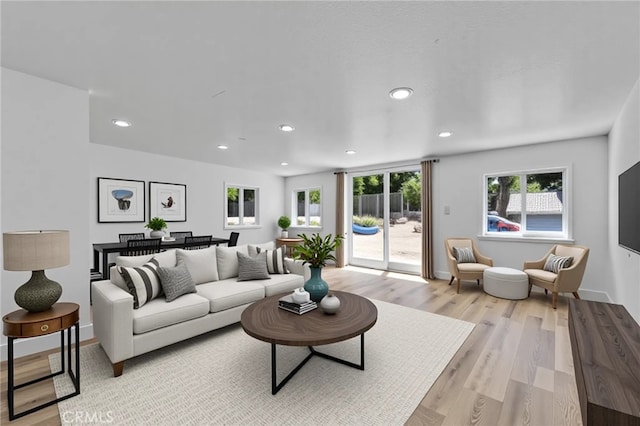 living room featuring baseboards, light wood finished floors, and recessed lighting