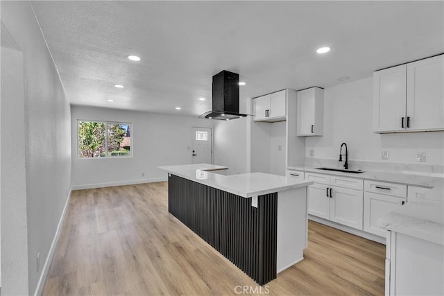 kitchen with white cabinetry, recessed lighting, a center island, a sink, and extractor fan
