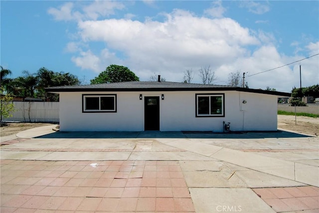 ranch-style house featuring a patio, stucco siding, and fence