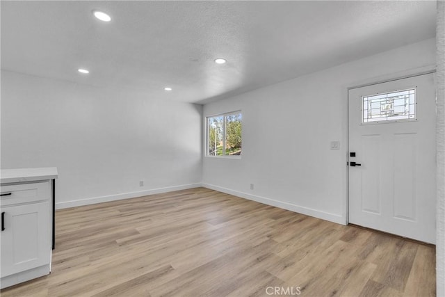 interior space with light wood-style flooring, recessed lighting, baseboards, and a wealth of natural light