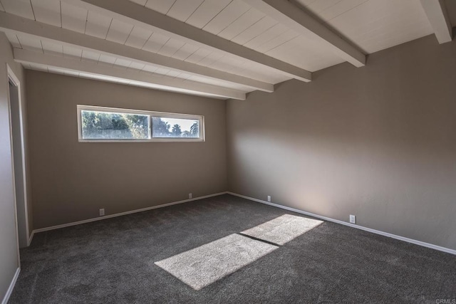 spare room featuring beamed ceiling, baseboards, and dark colored carpet