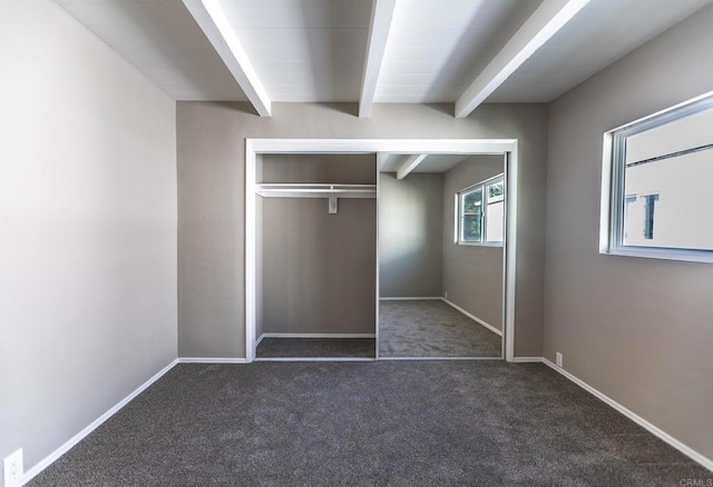 unfurnished bedroom with beam ceiling, baseboards, a closet, and carpet
