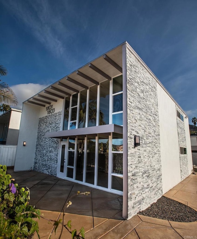 rear view of property with a patio and stucco siding