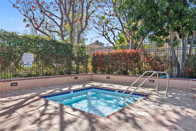 view of swimming pool with a community hot tub and fence
