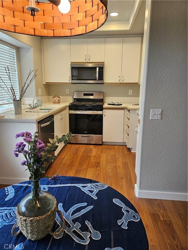 183 Cinnamon Teal, Aliso Viejo, CA 92656 - kitchen featuring stainless steel appliances, light countertops, a sink, light wood-style flooring, and white cabinetry