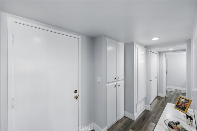 hall featuring baseboards, recessed lighting, and dark wood-style floors