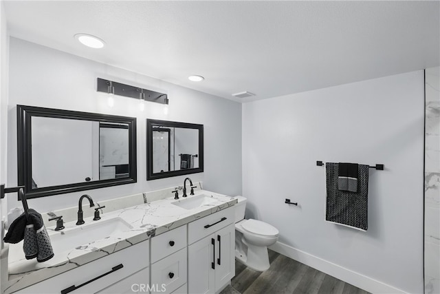 full bathroom with baseboards, a sink, wood finished floors, and toilet