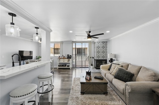 living area with recessed lighting, ornamental molding, dark wood finished floors, and ceiling fan