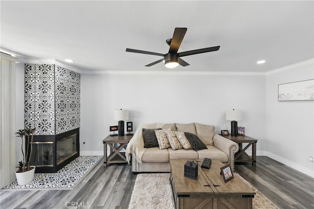 living room featuring ornamental molding, a fireplace, recessed lighting, and wood finished floors