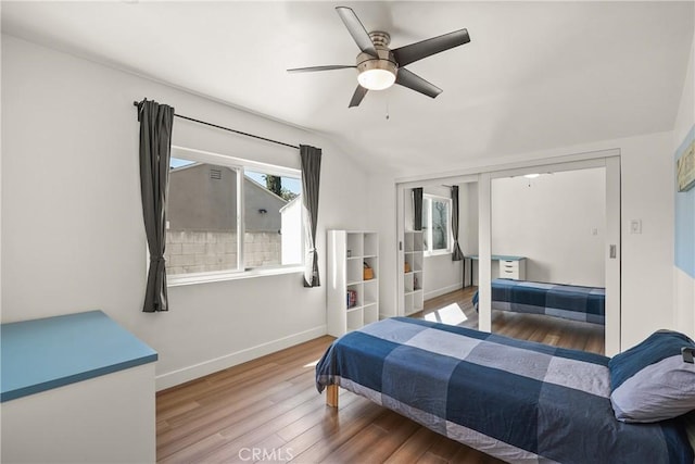 bedroom featuring wood finished floors, baseboards, a ceiling fan, and vaulted ceiling
