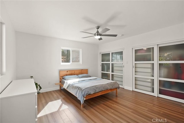 bedroom with wood finished floors, ceiling fan, and baseboards