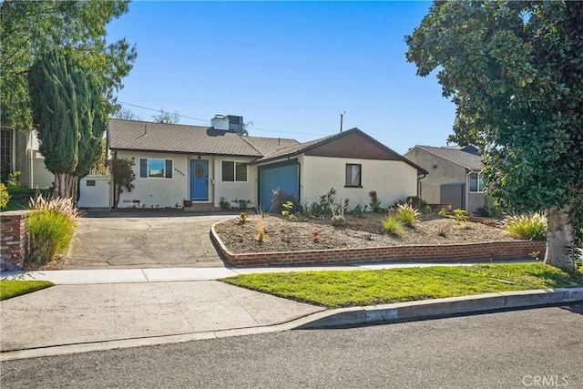ranch-style house with driveway, stucco siding, and an attached garage