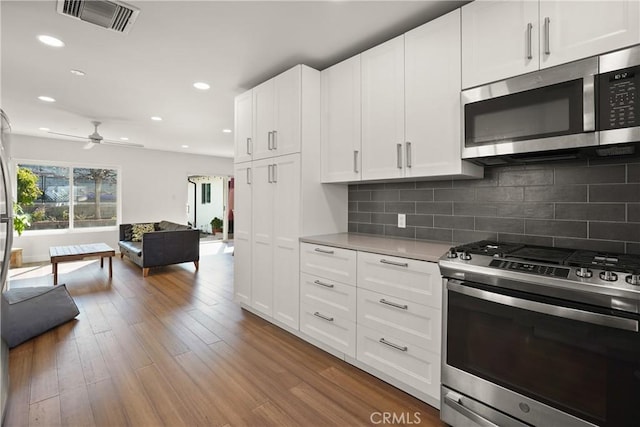 kitchen with visible vents, recessed lighting, light countertops, stainless steel appliances, and open floor plan