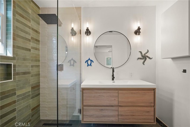 full bath with tiled shower and vanity