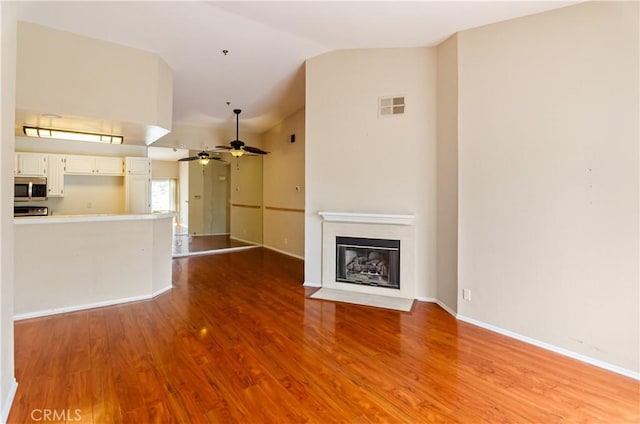 653 Oak Run Trl Unit Tl402, Oak Park, CA 91377 - unfurnished living room with visible vents, lofted ceiling, wood finished floors, ceiling fan, and a fireplace with flush hearth