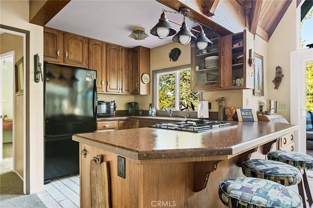 256 B Ln, Lake Arrowhead, CA 92352 - kitchen featuring freestanding refrigerator, gas cooktop, a peninsula, brown cabinetry, and a breakfast bar