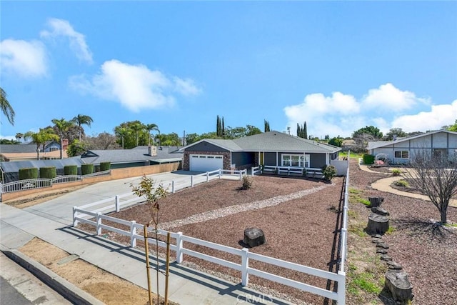 ranch-style house featuring driveway and a fenced front yard