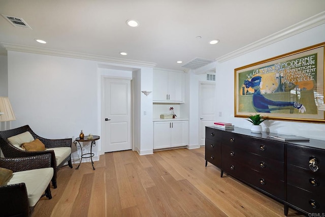 living area featuring light wood-type flooring, recessed lighting, crown molding, and visible vents