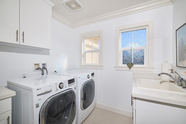 laundry room featuring visible vents, crown molding, washing machine and clothes dryer, cabinet space, and a sink