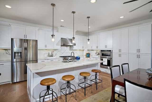kitchen with a sink, appliances with stainless steel finishes, under cabinet range hood, and white cabinetry