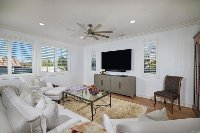 living area with plenty of natural light, ornamental molding, and recessed lighting