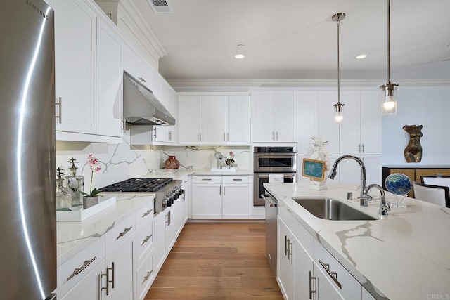 kitchen featuring appliances with stainless steel finishes, a sink, white cabinetry, under cabinet range hood, and visible vents
