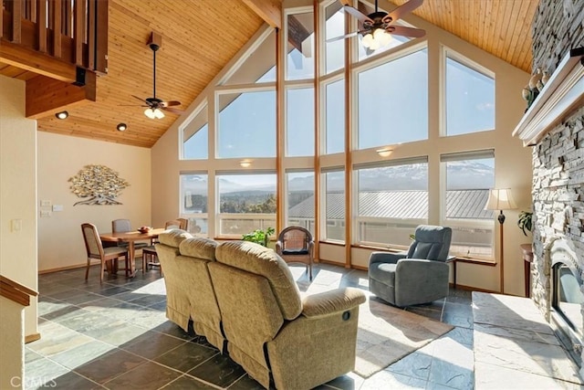 15516 Valley View Dr, Weed, CA 96094 - living room with wood ceiling, beam ceiling, a ceiling fan, and a stone fireplace