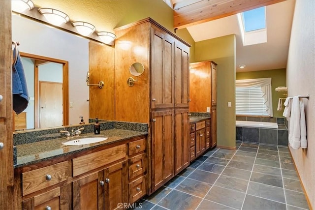 15516 Valley View Dr, Weed, CA 96094 - full bath with a relaxing tiled tub, a sink, lofted ceiling with skylight, and two vanities