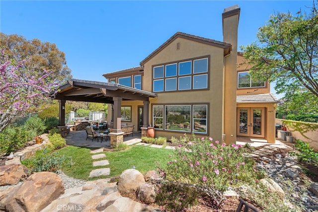 2 Williamsburg Ln, Coto De Caza, CA 92679 - back of house with stucco siding, a chimney, a patio area, fence, and french doors