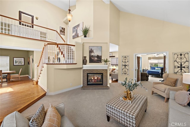 10 Cambridge Ct, Coto De Caza, CA 92679 - carpeted living area with high vaulted ceiling, baseboards, a brick fireplace, stairway, and ceiling fan