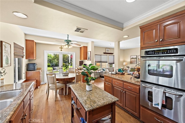 10 Cambridge Ct, Coto De Caza, CA 92679 - kitchen with stainless steel double oven, crown molding, light stone countertops, light wood-style flooring, and recessed lighting