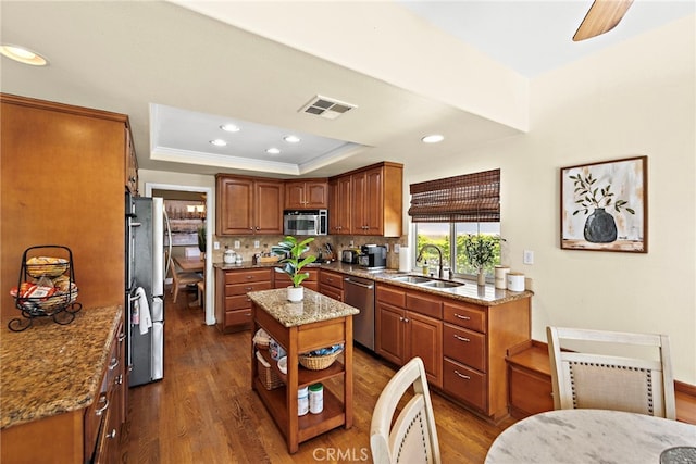 10 Cambridge Ct, Coto De Caza, CA 92679 - kitchen featuring stainless steel appliances, a sink, a raised ceiling, dark wood-type flooring, and light stone countertops