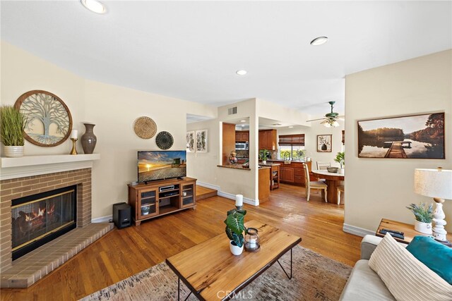 10 Cambridge Ct, Coto De Caza, CA 92679 - living area with a fireplace, light wood finished floors, a ceiling fan, recessed lighting, and baseboards