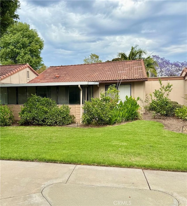 3173 Via Vis Unit C, Laguna Woods, CA 92637 - back of house with a tiled roof, a lawn, and stucco siding