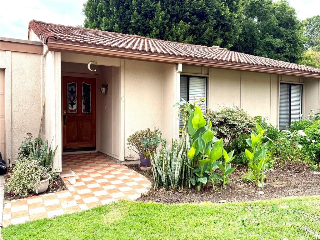 3173 Via Vis Unit C, Laguna Woods, CA 92637 - doorway to property featuring stucco siding and a tiled roof