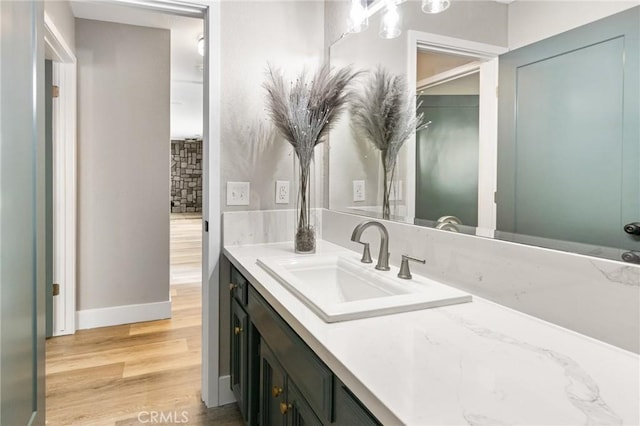 bathroom featuring vanity, baseboards, and wood finished floors