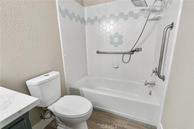 bathroom with a textured wall, shower / tub combination, vanity, toilet, and wood finished floors