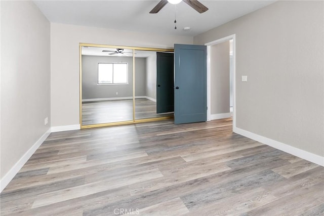 spare room featuring baseboards, ceiling fan, and wood finished floors