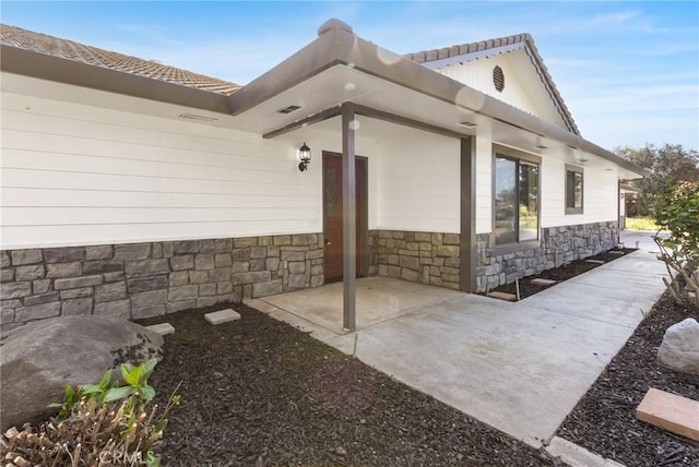 5703 Violet Ct, Atwater, CA 95301 - view of exterior entry with stone siding and a patio
