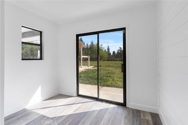 doorway to outside with baseboards and wood finished floors