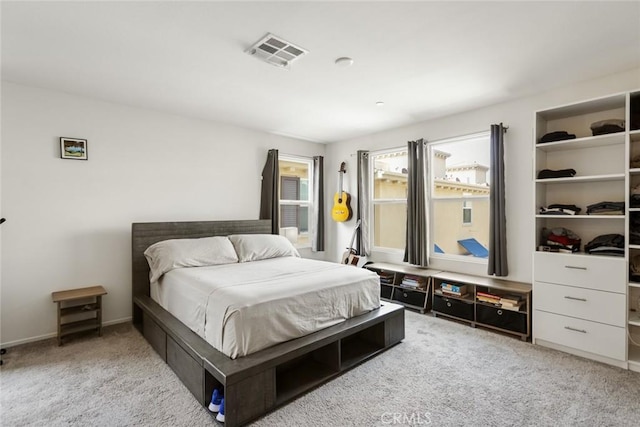 bedroom featuring visible vents and light carpet
