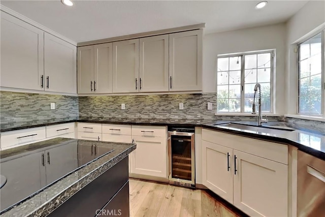 2100 Sherwood Ave Unit A, Modesto, CA 95350 - kitchen featuring black electric cooktop, a sink, light wood-type flooring, beverage cooler, and backsplash