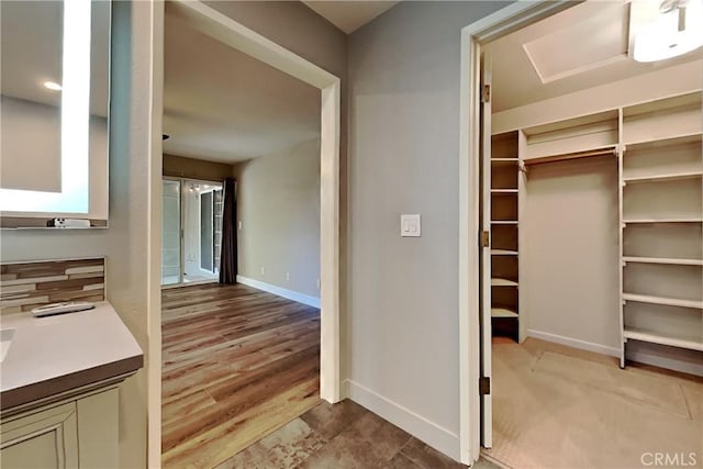2100 Sherwood Ave Unit A, Modesto, CA 95350 - bathroom with baseboards, a walk in closet, wood finished floors, and vanity